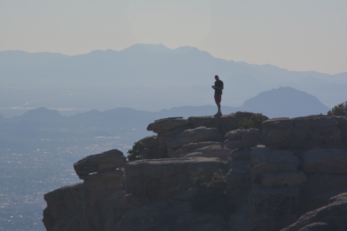 guy standing on the hgihest rock at Windy Point Vista